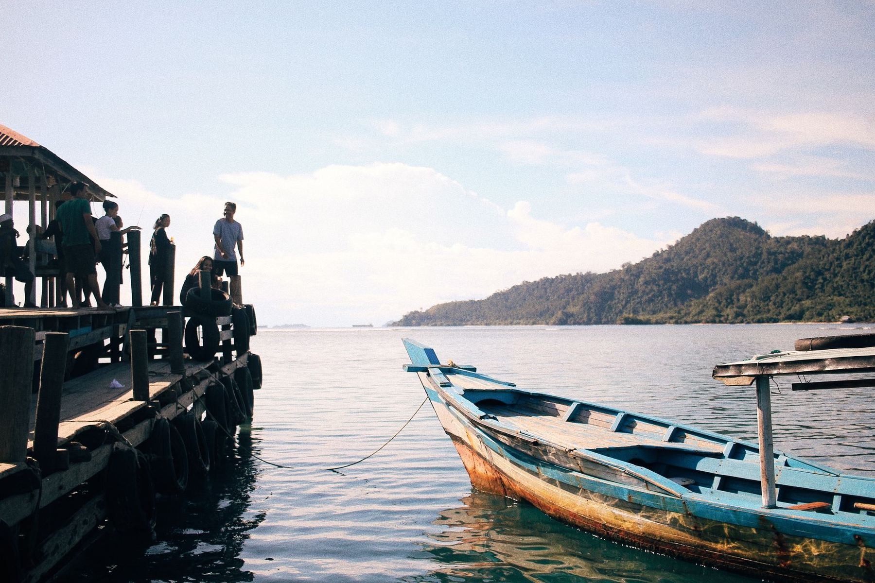 People on a pier beside a moored boat