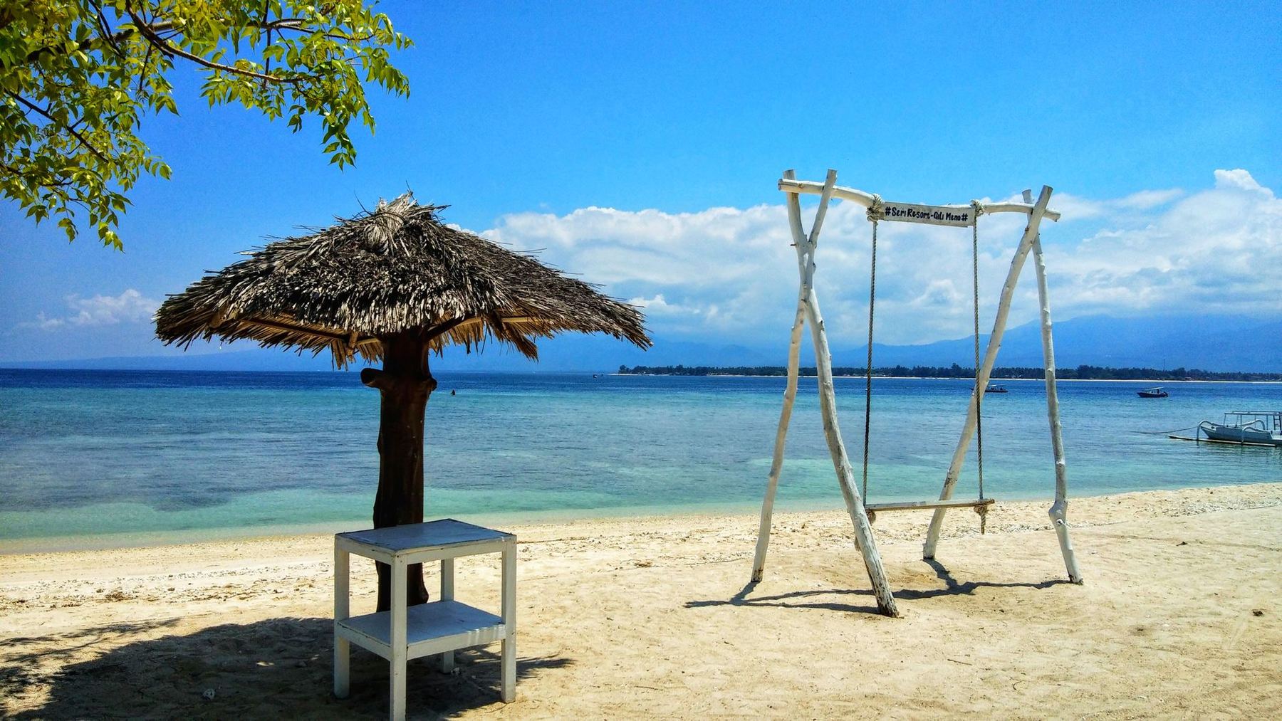 Beach swing under a thatched umbrella, West Nusa Tenggara