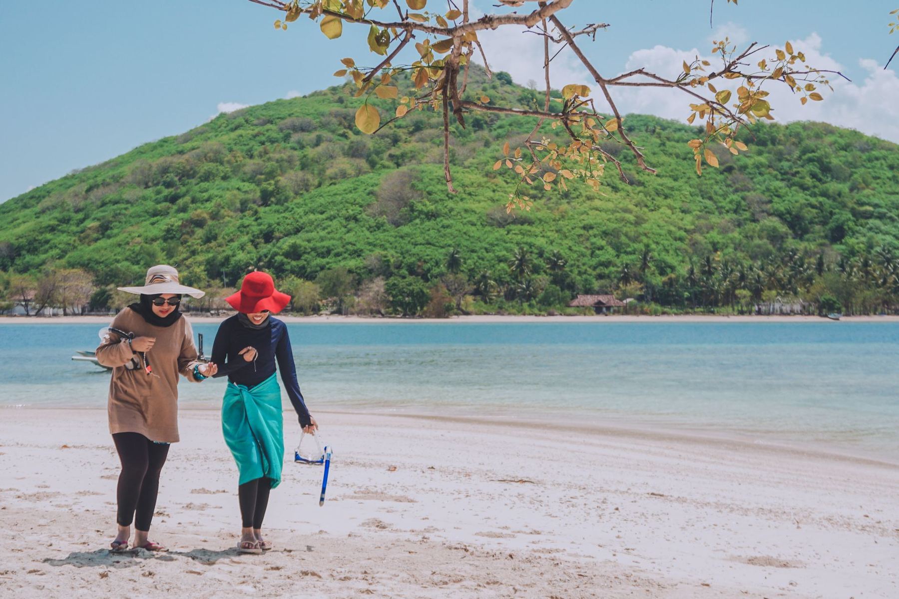 Two people walking a tropical beach, West Nusa Tenggara